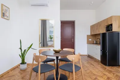 a kitchen with a table and chairs and a refrigerator at Kazimierz Area - Augustiańska 1 street in Kraków