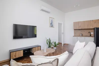a living room with a white couch and a tv at 2 Bedroom Apartment for 6 - Augustiańska 1 street in Kraków