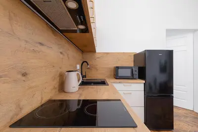 a kitchen with a black refrigerator and a sink at 2 Bedroom Apartment for 6 - Augustiańska 1 street in Kraków