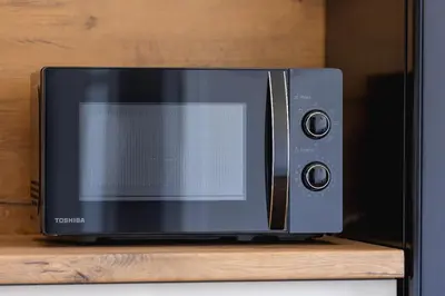 a microwave oven sitting on top of a wooden shelf at 2 Bedroom Apartment for 6 - Augustiańska 1 street in Kraków