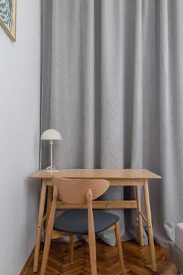 a wooden table and a chair with a lamp on it at 2 Bedroom Apartment for 6 - Augustiańska 1 street in Kraków