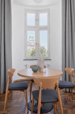 a table and chairs in a room with a window at 2 Bedroom Apartment for 6 - Augustiańska 1 street in Kraków