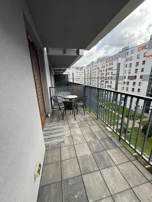 a balcony with a table and chairs on a balcony at Mieszkanie z parkingiem podziemnym Przewóz Podgórze in Kraków