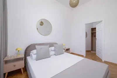 a white bedroom with a bed and a mirror at Jewish Quarter - Augustiańska 1 street in Kraków