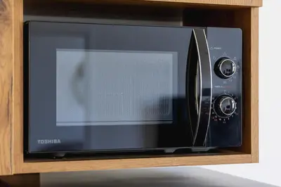 a microwave oven sitting in a wooden cabinet at Jewish Quarter - Augustiańska 1 street in Kraków