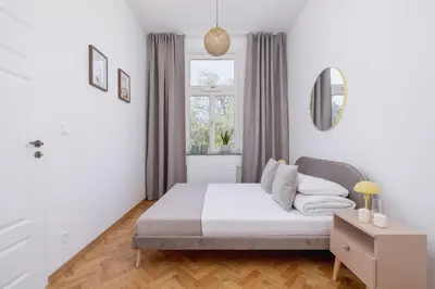 a white bedroom with a bed and a window at Jewish Quarter - Augustiańska 1 street in Kraków
