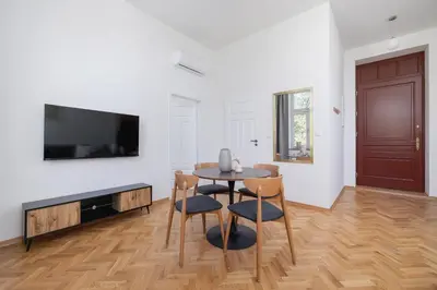 a living room with a table and chairs and a tv at Jewish Quarter - Augustiańska 1 street in Kraków