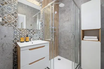 a bathroom with a shower and a white sink at 1 bedroom Apartment - Augustiańska 1 street in Kraków