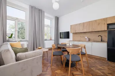 a kitchen and living room with a couch and a table at 1 bedroom Apartment - Augustiańska 1 street in Kraków