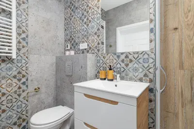 a bathroom with a white sink and a toilet at 1 bedroom Apartment - Augustiańska 1 street in Kraków