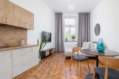 a kitchen and living room with a table and a couch at Studio with AC - Augustiańska 1 in Kraków