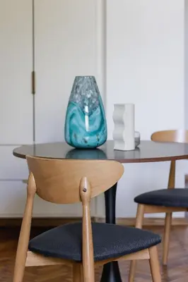a table and chair with a vase on top of it at Studio with AC - Augustiańska 1 in Kraków