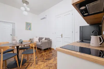 a kitchen and living room with a table and a couch at Apartment with the balcony - Augustiańska 1 in Kraków