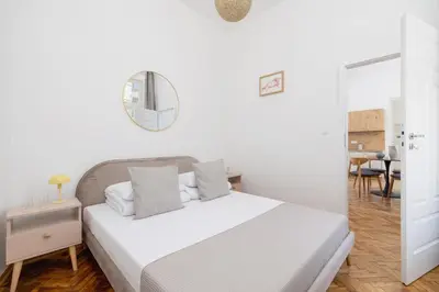 a white bedroom with a bed and a mirror at Apartment with the balcony - Augustiańska 1 in Kraków