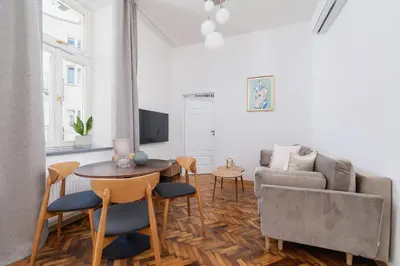 a living room with a couch and a table and chairs at Apartment with the balcony - Augustiańska 1 in Kraków