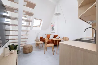a kitchen and living room with a spiral staircase at Cosy loft apartment - Jewish Quarter in Kraków