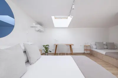 a white bedroom with a bed and a couch at Cosy loft apartment - Jewish Quarter in Kraków