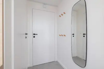 a dressing room with white cabinets and a mirror at Cosy loft apartment - Jewish Quarter in Kraków
