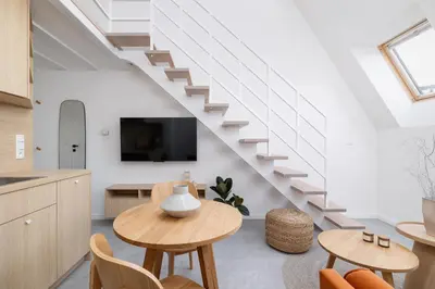 a living room with a table and a staircase at Cosy loft apartment - Jewish Quarter in Kraków