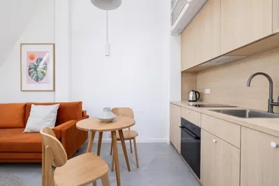 a kitchen and living room with a couch and a table at Cosy loft apartment - Jewish Quarter in Kraków