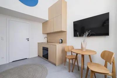 a kitchen with a table and chairs and a tv at Cozy studio - Augustiańska 1 in Kraków