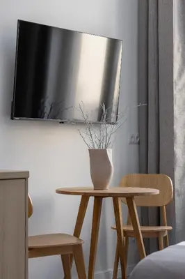 a table with a vase on it with two chairs at Cozy studio - Augustiańska 1 in Kraków