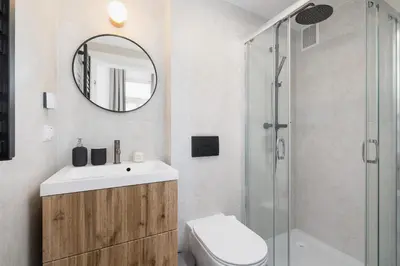 a bathroom with a sink toilet and a mirror at Cozy studio - Augustiańska 1 in Kraków