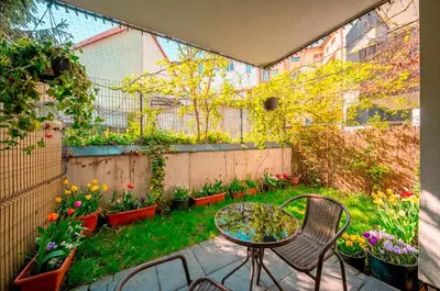 a small garden with a table and chairs and flowers at Verona ElevenFive in Kraków