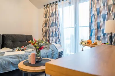 a living room with a couch and a table with flowers at Kraków Studio - Vistula River nearby - by Rentujemy in Kraków