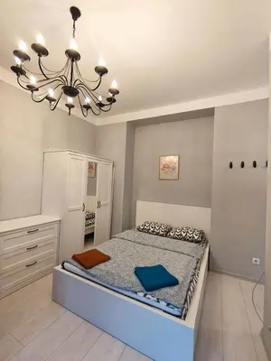 a bedroom with a bed and a chandelier at Daniel Apart Hotel Krakow Comfort in Kraków
