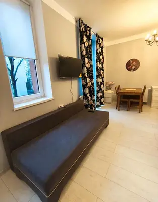 a black couch in a living room with a table at Daniel Apart Hotel Krakow Comfort in Kraków