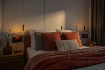 a bedroom with a bed with orange and white pillows at Apartamenty Lew Invest obok Rynku Głównego 279, Parking w cenie in Kraków