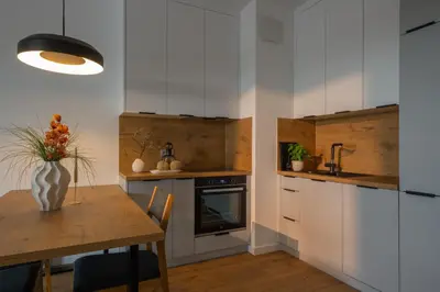 a kitchen with a wooden table with vases on it at Apartamenty Lew Invest obok Rynku Głównego 279, Parking w cenie in Kraków