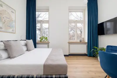 a bedroom with a large bed and two windows at Jewish Quarter- Augustiańska 1- AC in Kraków