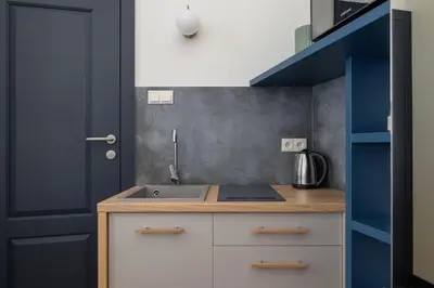 a small kitchen with a sink and a blue door at Apartment- AC - Augustiańska 1- Jewish Quarter in Kraków