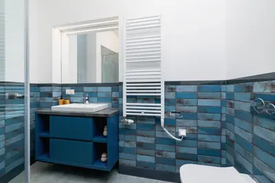a bathroom with blue tiles and a sink at Apartment- AC - Augustiańska 1- Jewish Quarter in Kraków