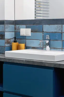 a white sink in a bathroom with blue tiles at Apartment- AC - Augustiańska 1- Jewish Quarter in Kraków