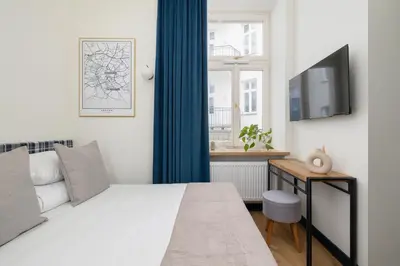 a bedroom with a bed and a flat screen tv at Apartment - Augustiańska 1 - Studio for 2 in Kraków