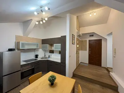 a kitchen and dining room with a wooden table at Apartment next to Wawel Castle and the Vistula River, air conditioning in Kraków