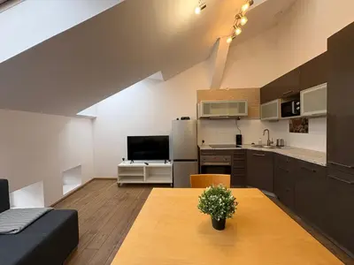 a kitchen and living room with a table and a couch at Apartment next to Wawel Castle and the Vistula River, air conditioning in Kraków