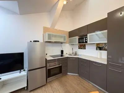 a kitchen with a stainless steel refrigerator and a tv at Apartment next to Wawel Castle and the Vistula River, air conditioning in Kraków