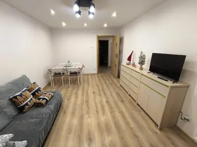 a living room with a couch and a flat screen tv at A cozy corner of Płaszów in Kraków