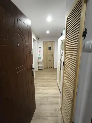 a hallway with white walls and a wooden floor at A cozy corner of Płaszów in Kraków