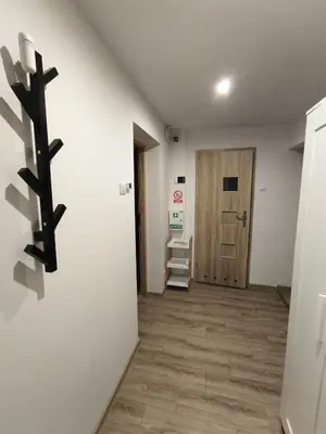 a small refrigerator in a room next to a door at A cozy corner of Płaszów in Kraków