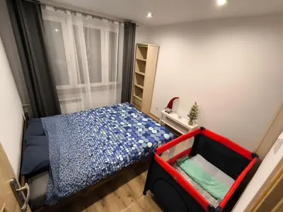 a small bedroom with a bed and a window at A cozy corner of Płaszów in Kraków