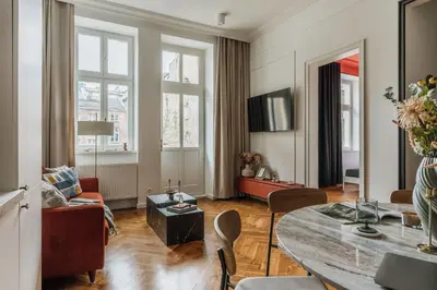 a living room with a table and a red couch at Pinata Apartment - Orzeszkowej 8 in Kraków