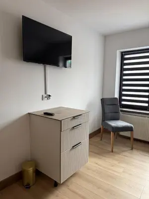 a room with a desk and a chair and a television at Wynajmowanie pokoi in Szczyglice