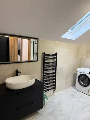 a bathroom with a sink and a washing machine at Wynajmowanie pokoi in Szczyglice