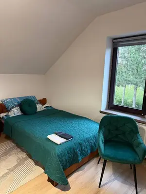 a bedroom with a green bed and a green chair at Wynajmowanie pokoi in Szczyglice