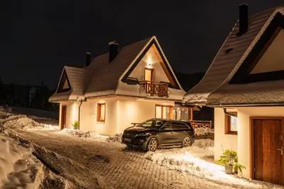 a car parked in front of a house at night at Burnosówka in Nowy Targ